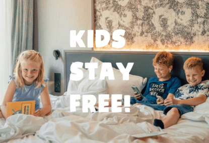 Kolme lasta hotellin sängyssä ja teksti ''kids stay free''